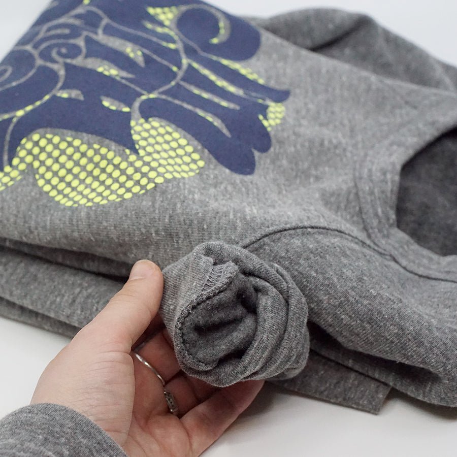 Detail of fleece "I'm with the Pack" Sweatshirt with a hand holding the right sleeve