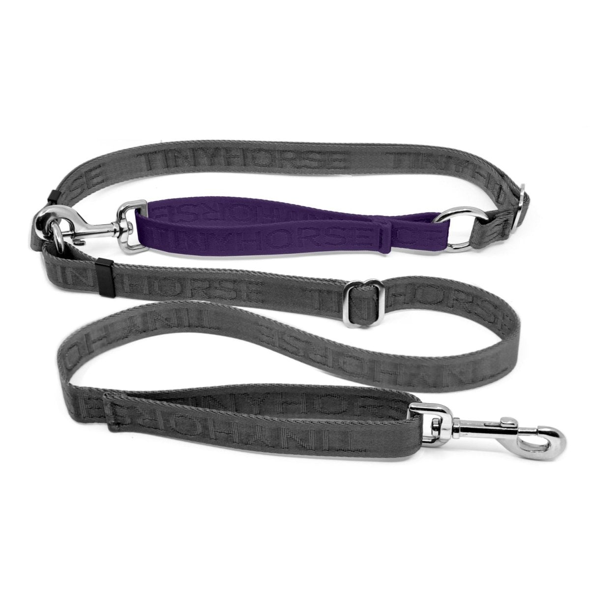 Adjustable hands-free dog leash with traffic handle. Grey with a purple colour accent in front of the hips. Attach more dogs using the rings sewn into the waist. Made of nylon embossed with “Tinyhorse.”