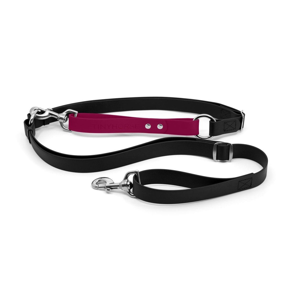 Adjustable hands-free dog leash with traffic handle. Black with an magenta colour accent in front of the hips. Attach more dogs using the rings sewn into the waist.