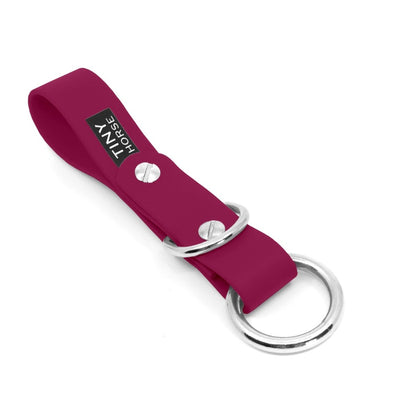 Short BioThane strap that slides onto a belt. Use this to walk dogs hands free by clipping their leashes to the metal ring at the end of the strap. There is also a dee ring for attach extra accessories. Colour is magenta.